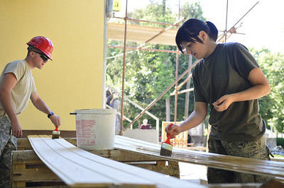 two soldiers painting wood