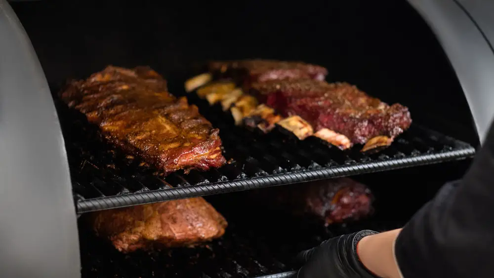 A barrel grill is used to prepare a large amount of meat