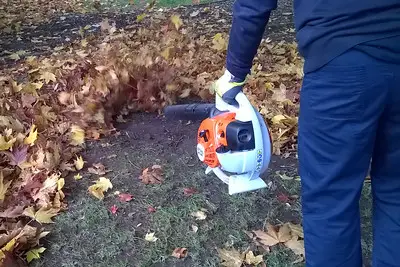 A man blowing leaves with a heavy duty cordless garden tool