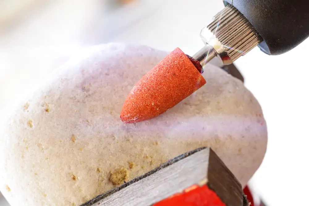 Sanding rock with hand-held equipment in close-up