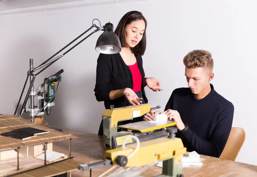 Two students creating architectural model