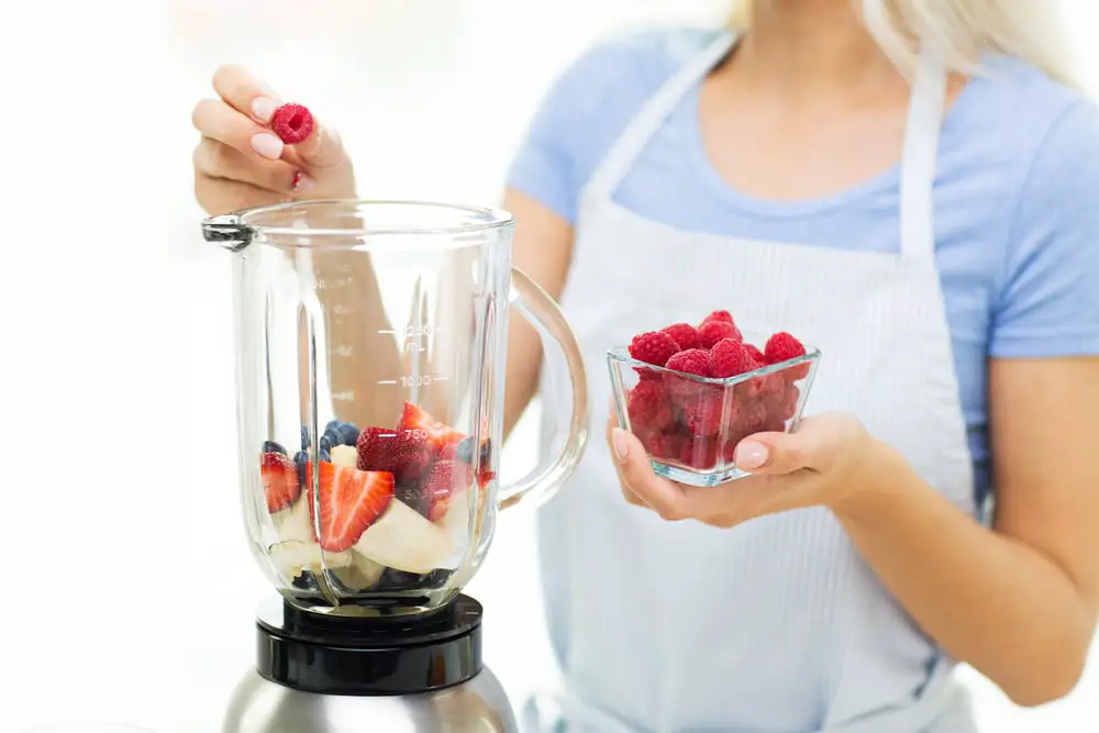 a woman making a healthy strawberry smoothie