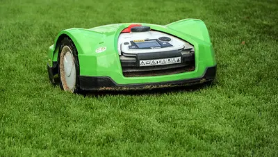 green robot mowing the grass