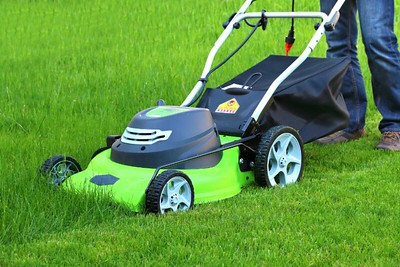 mowing grass with a green mower