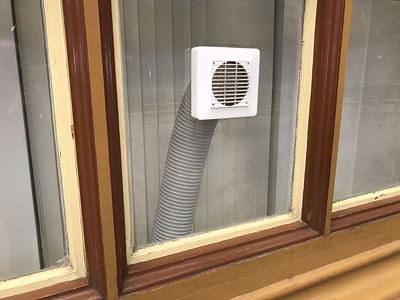 a window with a white box and tube that helps in ventilation