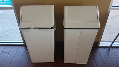 two-white-garbage-cans-placed-near-doors